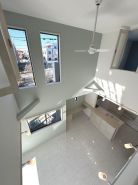【アーバンポート施工例】上部吹抜の天井高が開放感をもたらす広々リビング・ダイニング。ゆとりある空間だからこそできる仕様。明るい陽光が射し込み室内が光に包まれるように設計されています。
