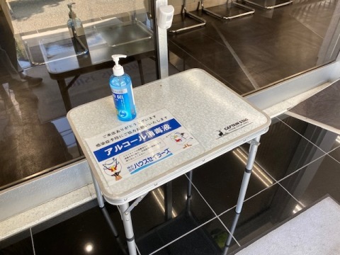 正面玄関にアルコール消毒液を設置しております。